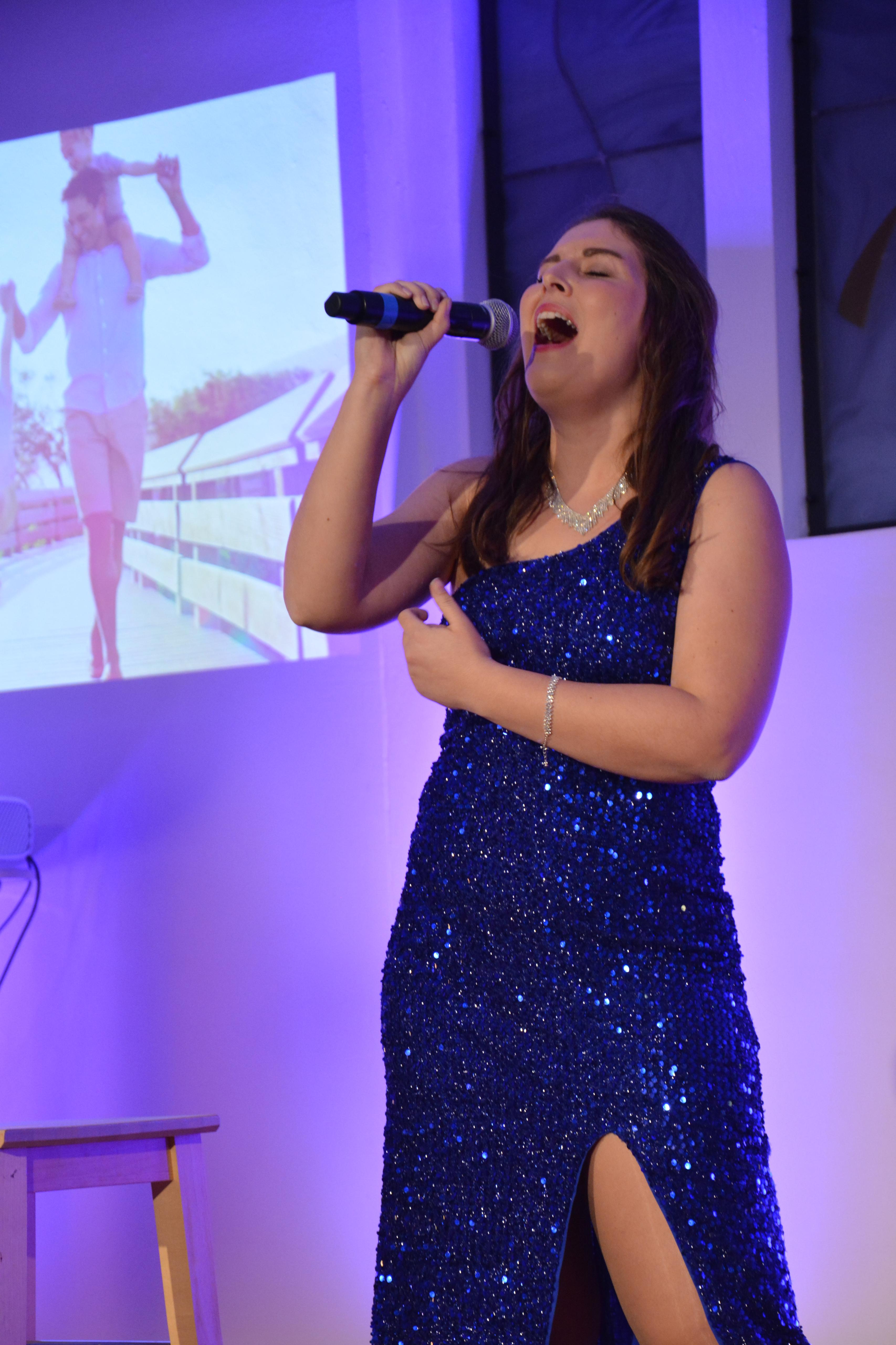 Hannah als Live-Sängerin im blauen Abendkleid bei einem Konzert auf der Bühne